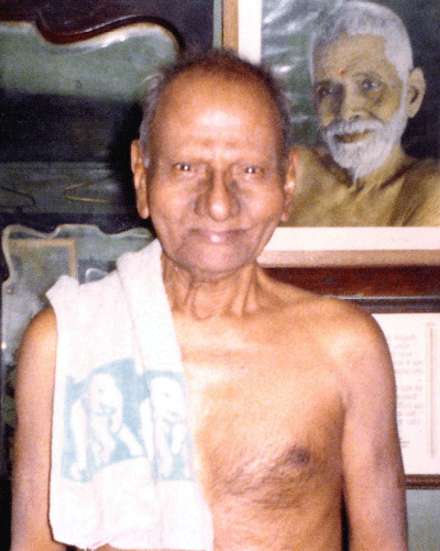012-0-Nisargadatta Maharaj with a photo of Sri Ramana Maharshi behind.gif